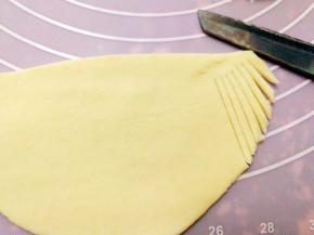 80克白色的面团擀成长18厘米，宽12厘米的椭圆形，再对折，用刀切出胡须的样子