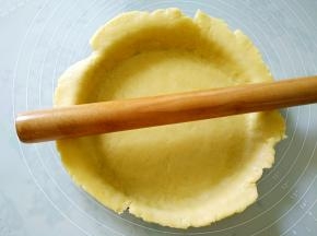 将饼皮铺在派盘里，贴紧，用擀面杖在派盘边沿擀一下，便可轻松去除多余的饼皮