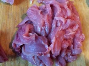 将猪里脊肉切片后放进蛋清里，加入适量的盐，腌半个小时