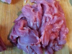 将猪里脊肉切片后放进蛋清里，加入适量的盐，腌半个小时