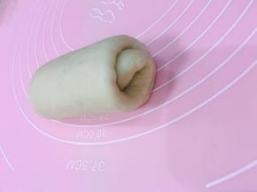 将醒好的面团，拿一个擀长，从上往下卷起来。