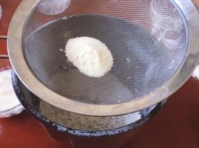 将低筋面粉和奶粉过筛到面包机中