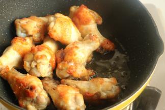 鸡翅根放入平底锅煎至油份逼出，表皮变焦香，这个过程大约5分钟。