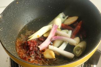 鸡翅根移出待用，利用煎出的油，炒香郫县豆瓣酱和香料等。