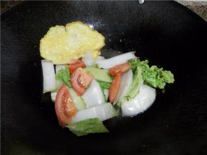 倒入白菜叶和番茄块炒均匀。