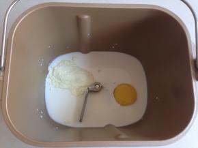 将牛奶、糖、盐、鸡蛋和奶粉投放进面包桶里