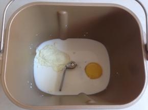 将牛奶、糖、盐、鸡蛋和奶粉投放进面包桶里