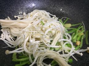 加少许盐至尖椒丝变软，下金针菇翻炒
