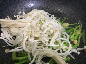 加少许盐至尖椒丝变软，下金针菇翻炒
