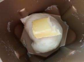 2.将面团揉至扩展阶段时，加入黄油继续揉。