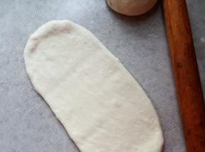 7.面团室温松弛十分钟，取一个面团用擀面杖擀成长方形。