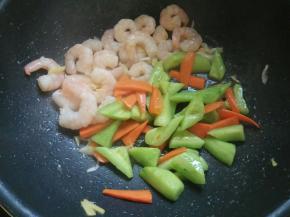 虾仁变色后加入瓜片、胡萝卜片。