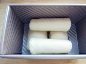 取一块擀成均匀的厚片，卷起，接口朝下
