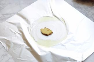 准备一张锡纸，中间涂上橄榄油，放上一片姜。