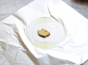 准备一张锡纸，中间涂上橄榄油，放上一片姜。