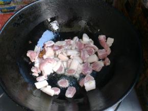 倒入猪肉，中小火翻炒一会，把有肥肉的地方熬出些猪油来。