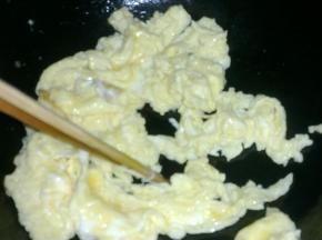 锅中倒油，下入鸡蛋液用筷子划散。