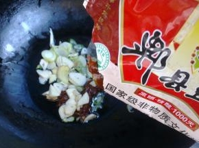 锅里倒入冷油，小火将葱姜蒜炸香，同时放入郫县豆瓣酱炸出红油。