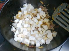 加入料酒、生抽、醋， 倒入切好的芋头丁翻炒均匀。