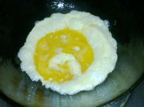 锅中倒油，油九成热的时候下入蛋液。