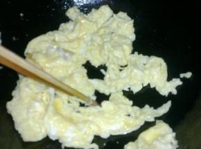 快速用筷子把快要凝结的蛋液搅散，搅成碎块。

盛出锅备用。