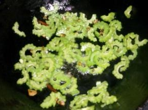 在葱姜蒜变色之前下入苦瓜翻炒片刻。