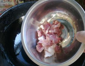 等花椒和大料变色后，下入猪肉翻炒。