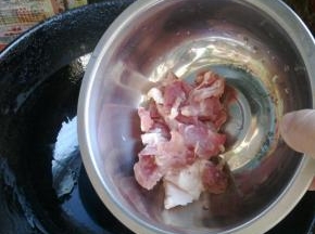 等花椒和大料变色后，下入猪肉翻炒。