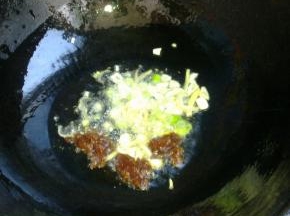 锅里倒油，冷油下入葱姜蒜和郫县豆瓣酱炸香。