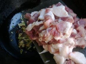 炸制微微变色后放入猪肉翻炒。