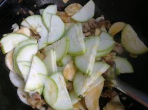 倒入些白酒去腥提香。倒入杏鲍菇翻炒片刻。再加入西葫芦翻炒。