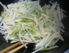 锅里中火爆香葱蒜。倒入土豆丝和尖椒一起翻炒。