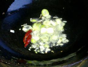 锅里倒入油，爆香葱蒜和干红辣椒。