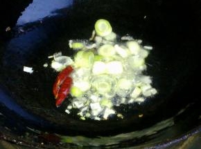 锅里倒入油，爆香葱蒜和干红辣椒。