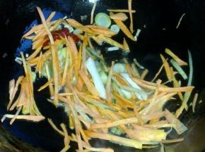锅里倒入油，爆香葱蒜和干红辣椒。下入胡萝卜翻炒。
