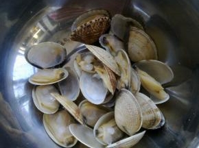 把不同时间张口的蛤蜊用筷子一一夹到碗里，用干净水再次冲洗一次。