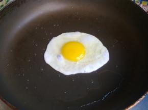 不粘锅里倒少许油，转一转，使油均匀涂满整个锅底，关小火，打入一个鸡蛋，表面上撒些盐，小火煎至蛋黄凝固。