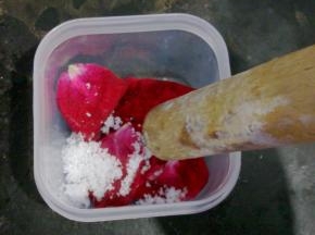 用擀面杖把花瓣和糖捣烂，均匀的使花瓣和糖融为一体。