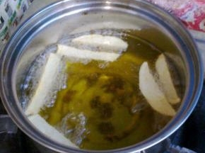 油锅里多倒些油，下入土豆条炸制表面金黄。