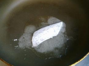 平底锅倒少许油，把沾好面粉的带鱼下锅煎。