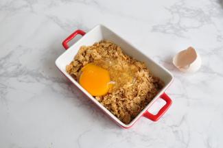 将即食麦片弄碎，放入鸡蛋