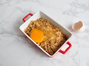 将即食麦片弄碎，放入鸡蛋