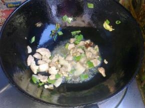 油冒烟后下入猪肉翻炒。