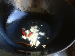 锅中倒油，下入干辣椒和蒜爆香。