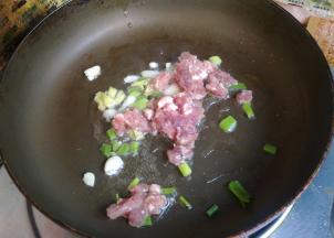 放入肉馅翻炒至变色。
