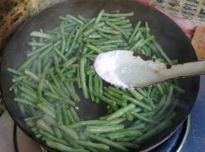 加入适量盐煸炒至长豆角表皮变皱。