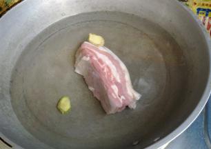 五花肉切成一指宽的长方形，冷水下锅煮至肉变硬，锅里放两片姜去腥。