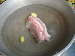五花肉切成一指宽的长方形，冷水下锅煮至肉变硬，锅里放两片姜去腥。