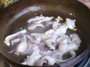 蒜末变成微黄后倒入鱿鱼翻炒。