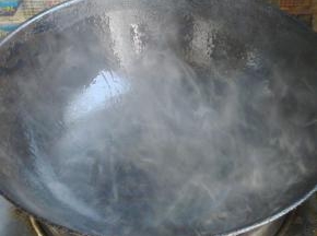 锅里倒入油，加热至锅边冒出浓厚的烟。